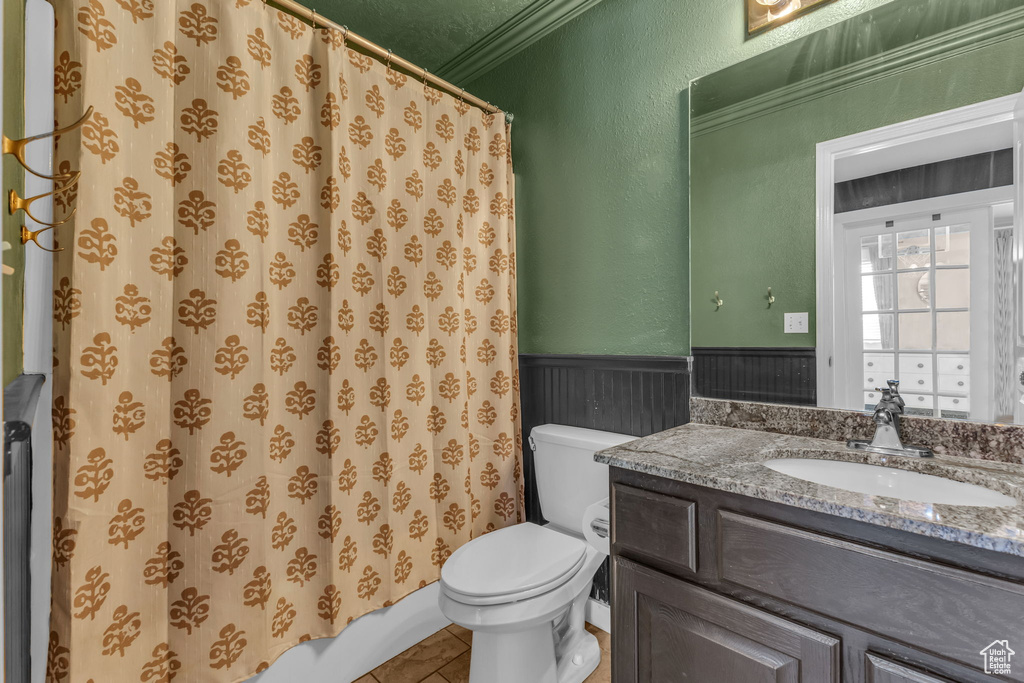 Full bath featuring wainscoting, toilet, vanity, ornamental molding, and a shower with curtain