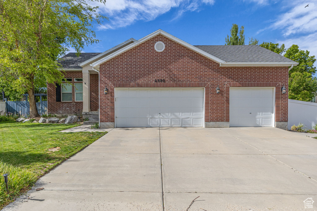 View of front of house with a garage, driveway, and brick siding