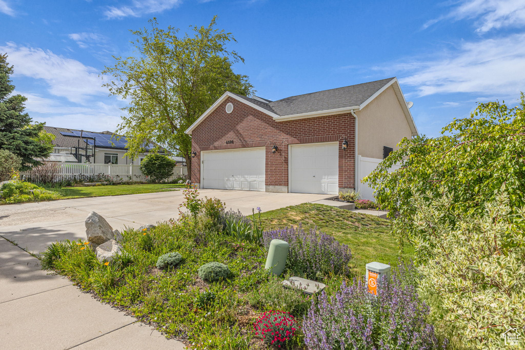 View of side of home with concrete driveway, brick siding, and a garage