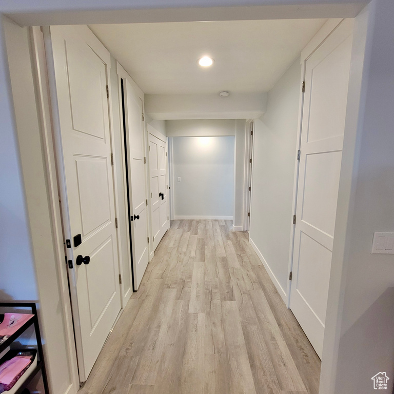 Hall with light wood-style floors, baseboards, and recessed lighting
