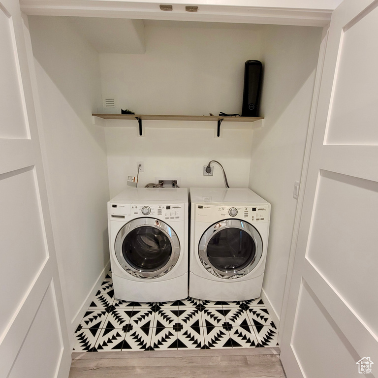 Washroom with independent washer and dryer, baseboards, and tile patterned flooring