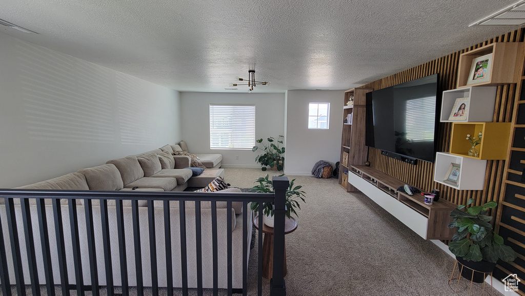 Carpeted living room with a textured ceiling and baseboards
