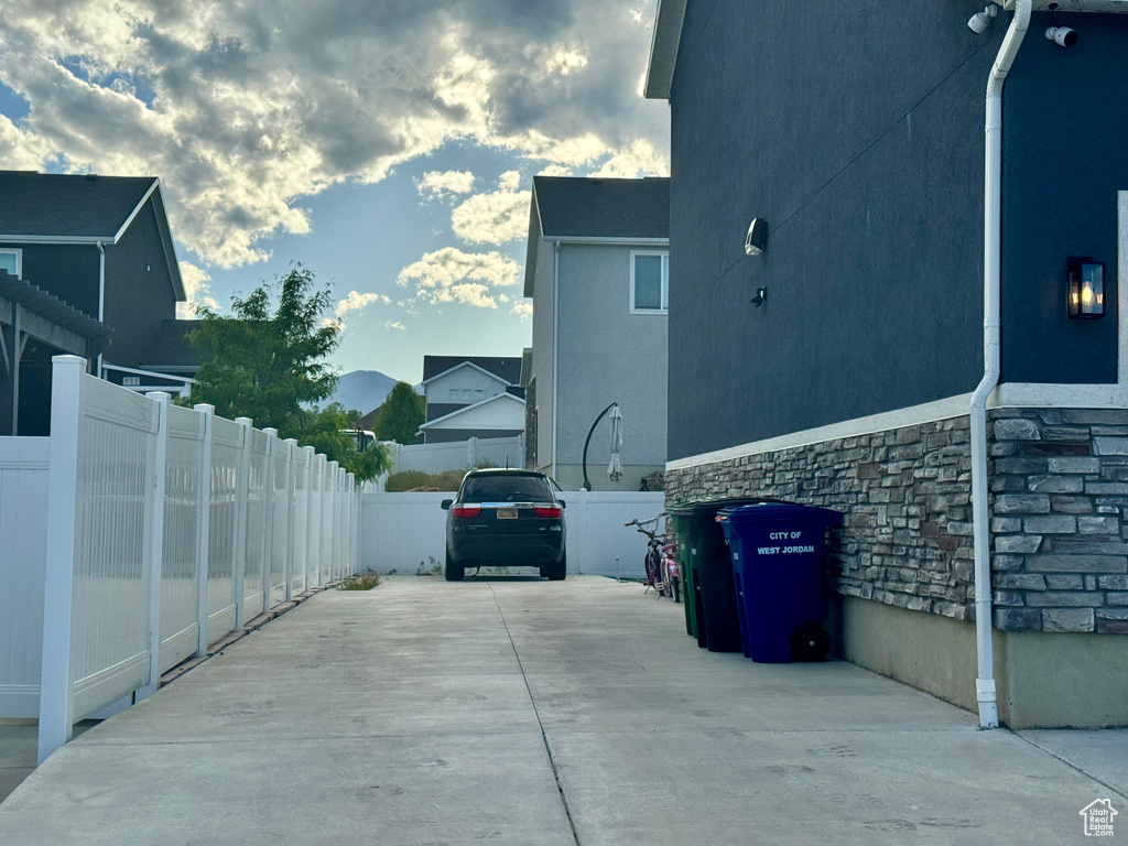 View of property exterior with concrete driveway, stone siding, and stucco siding