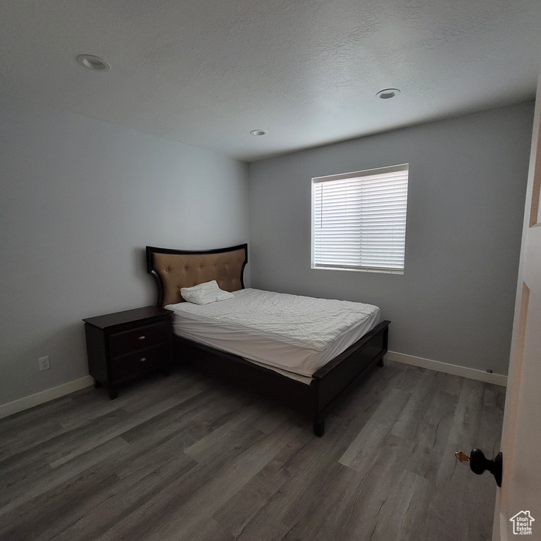 Bedroom with wood finished floors, baseboards, and recessed lighting