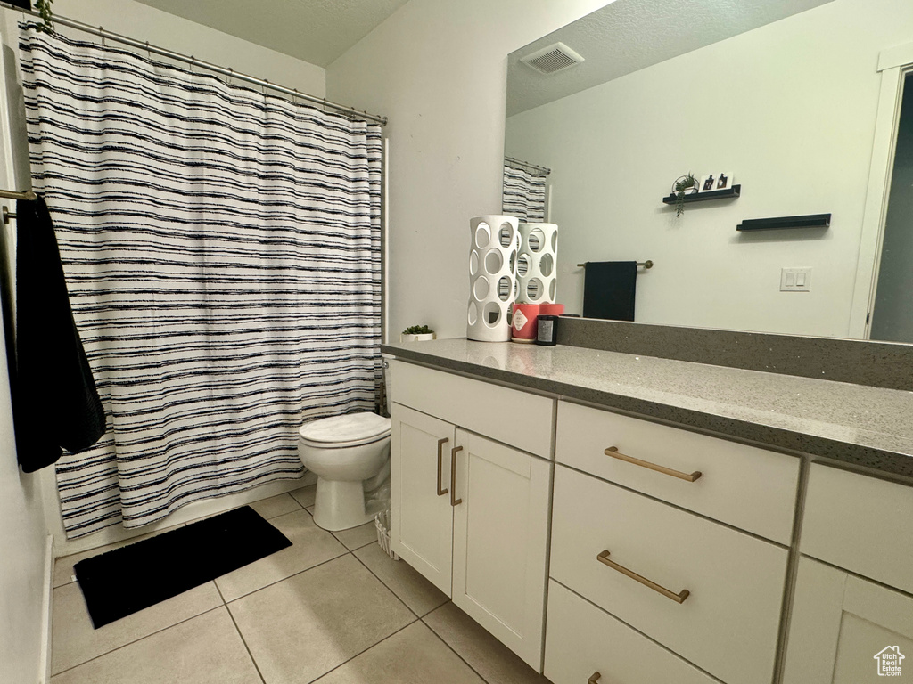 Bathroom featuring tile patterned floors, vanity, and toilet