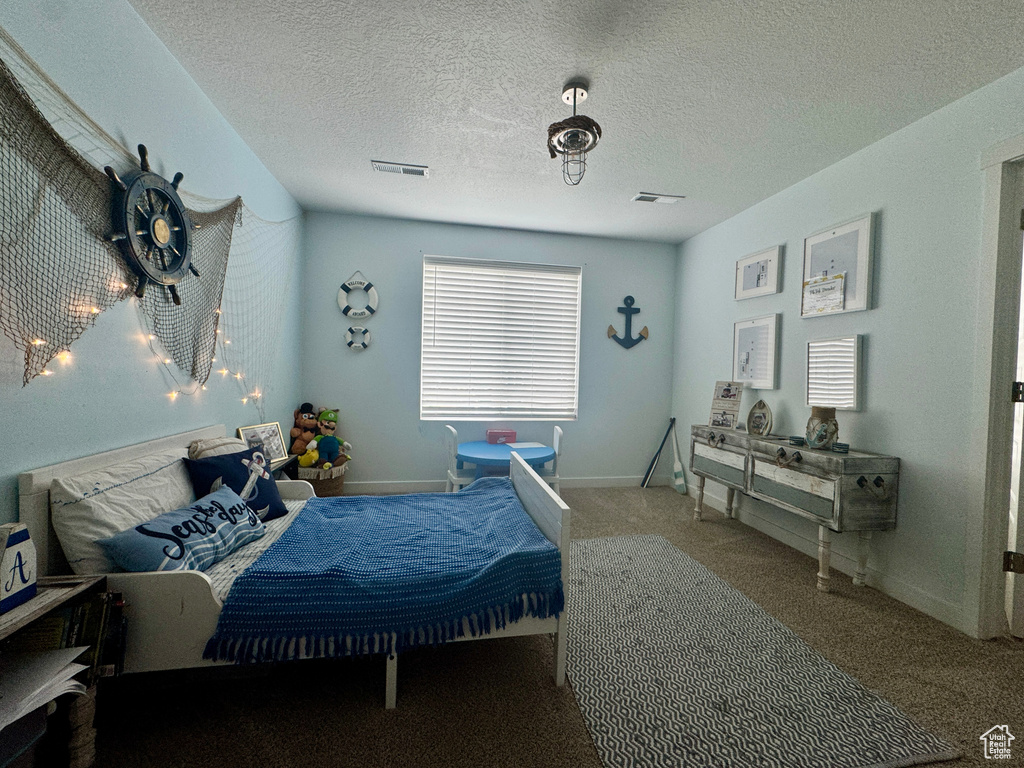 Bedroom with carpet floors, a textured ceiling, and baseboards
