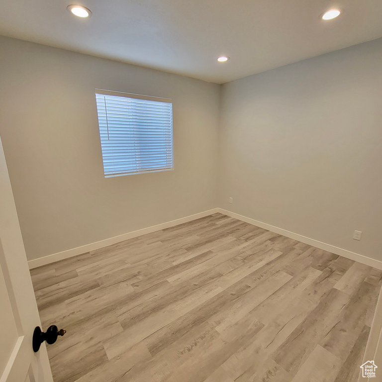 Unfurnished room featuring light wood finished floors, baseboards, and recessed lighting