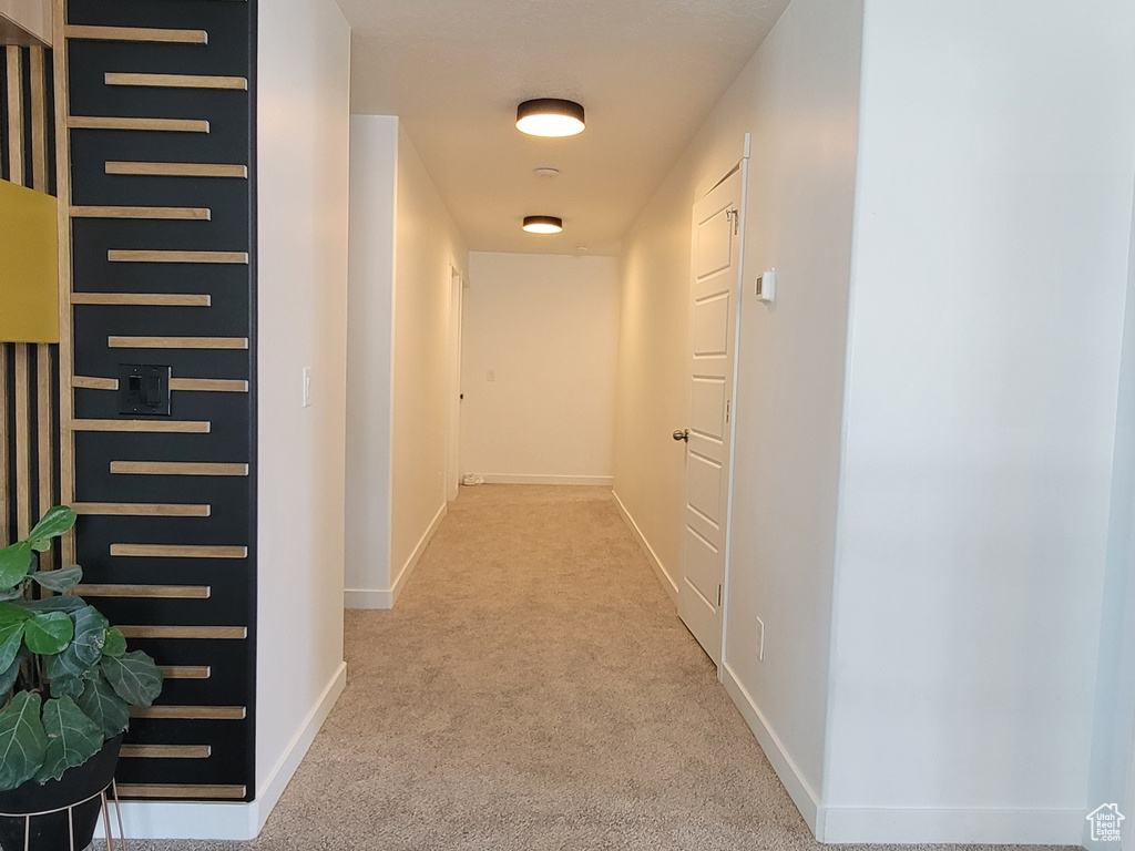 Hallway featuring carpet floors, baseboards, and a textured ceiling