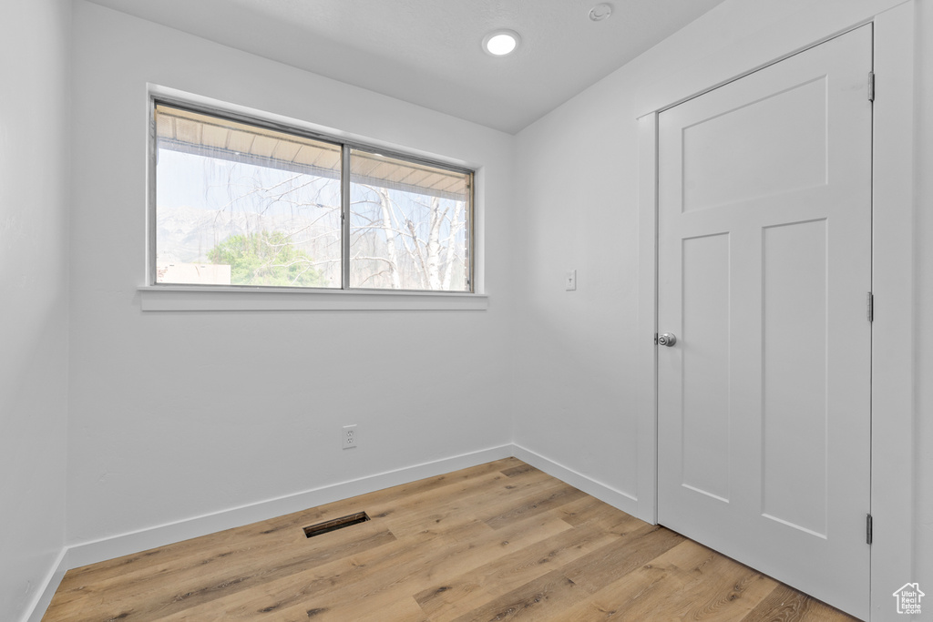 Empty room featuring baseboards, light wood finished floors, and recessed lighting