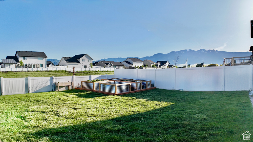 View of yard featuring a vegetable garden, a residential view, and a mountain view