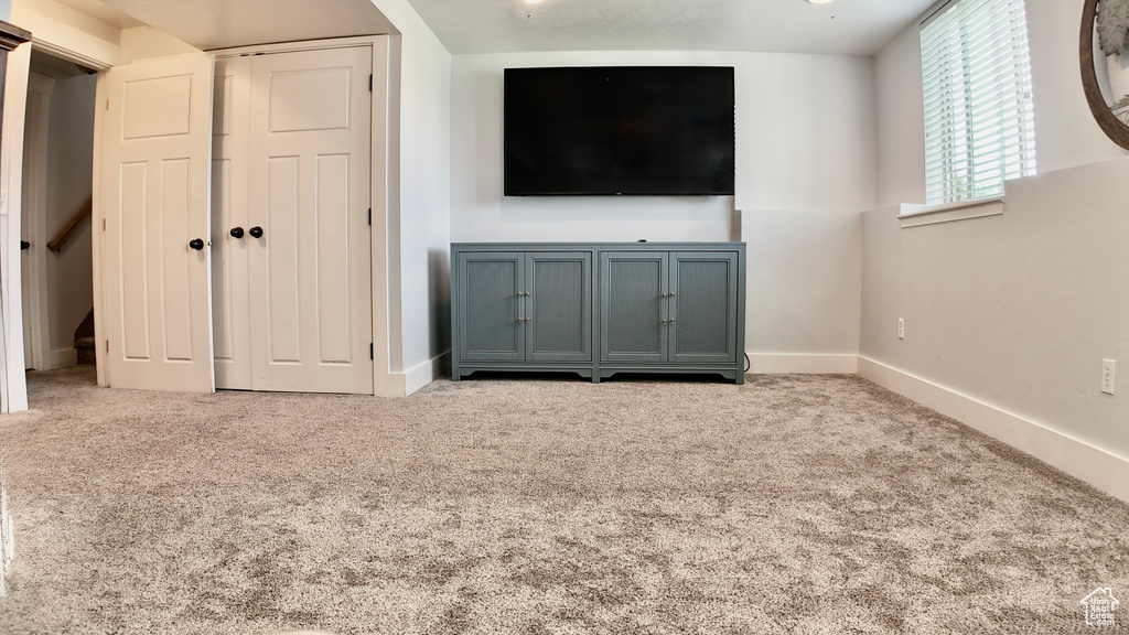 Unfurnished living room with carpet floors and baseboards