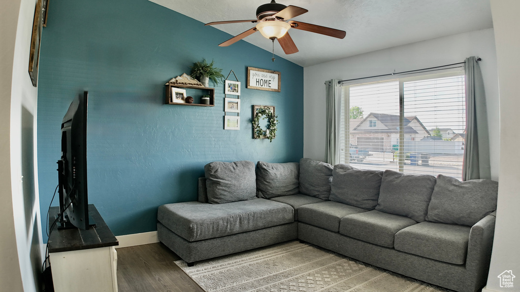 Living area with wood finished floors, a ceiling fan, and lofted ceiling