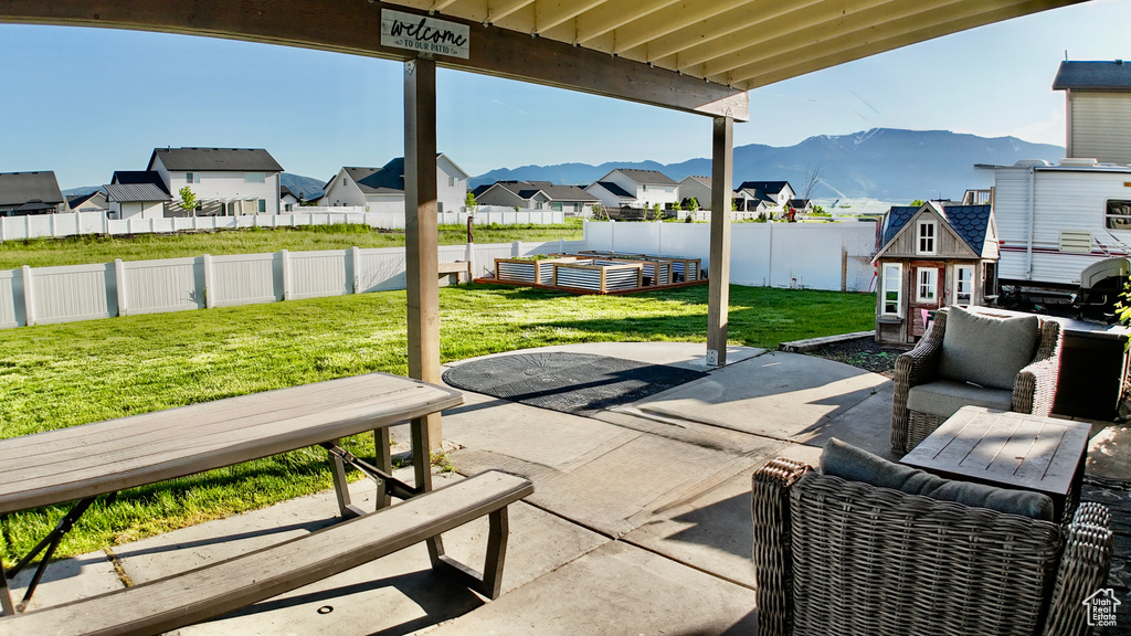 View of patio / terrace featuring a residential view, a mountain view, a vegetable garden, and an outdoor structure