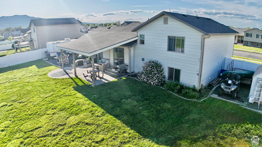 Rear view of property with a patio area, a shingled roof, outdoor lounge area, and a mountain view