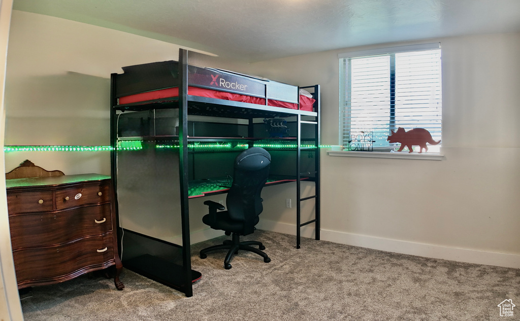 Bedroom featuring carpet flooring, baseboards, and an office area