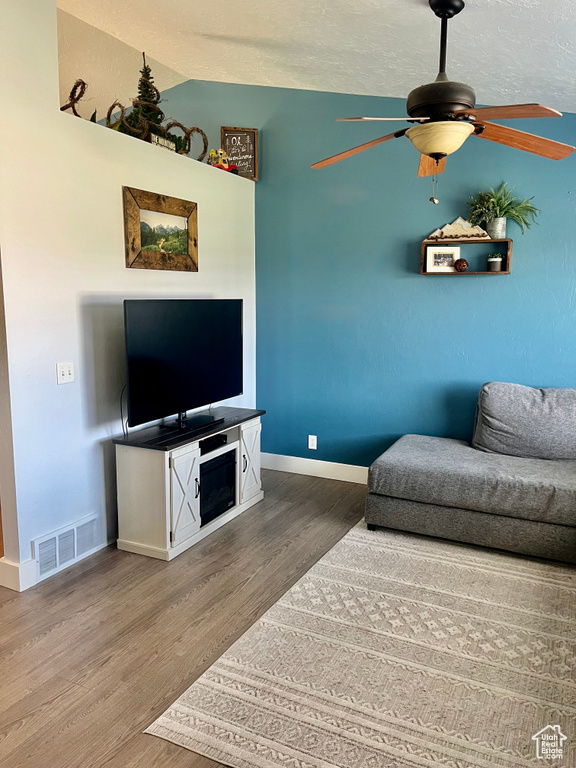 Living room with wood finished floors, baseboards, and a ceiling fan