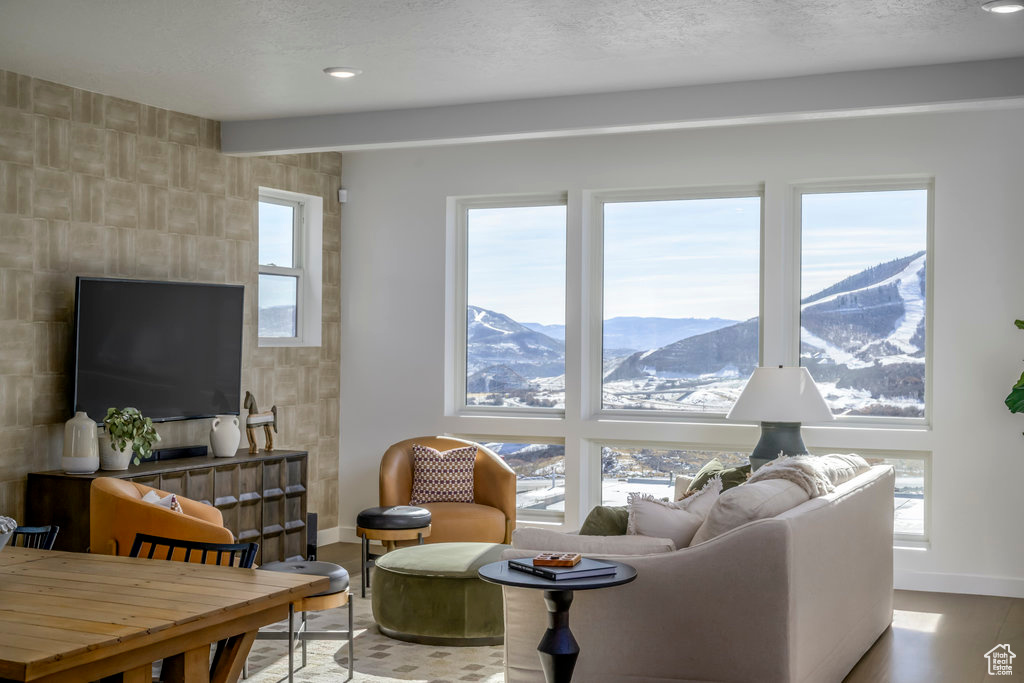 Living room with a mountain view, tile walls, baseboards, and wood finished floors