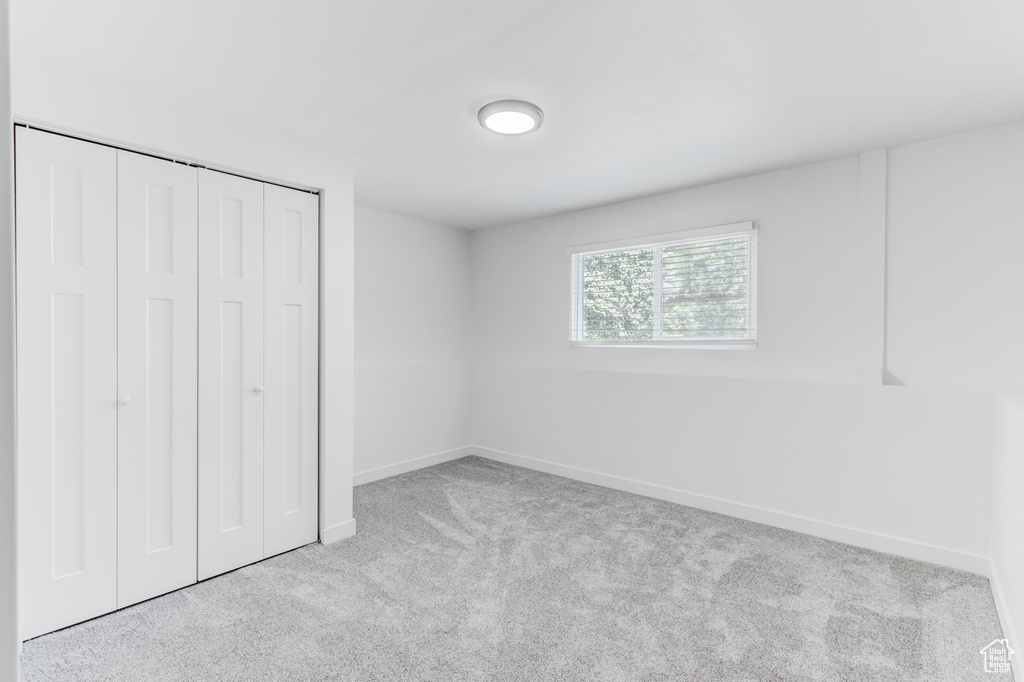 Unfurnished bedroom with carpet flooring, baseboards, and a closet