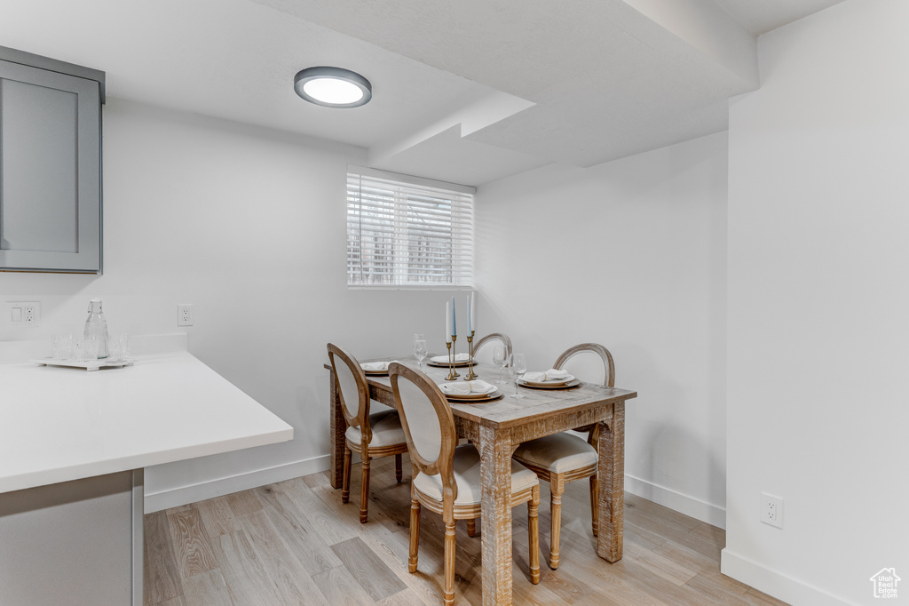 Dining space with light wood-style floors, baseboards, and bar