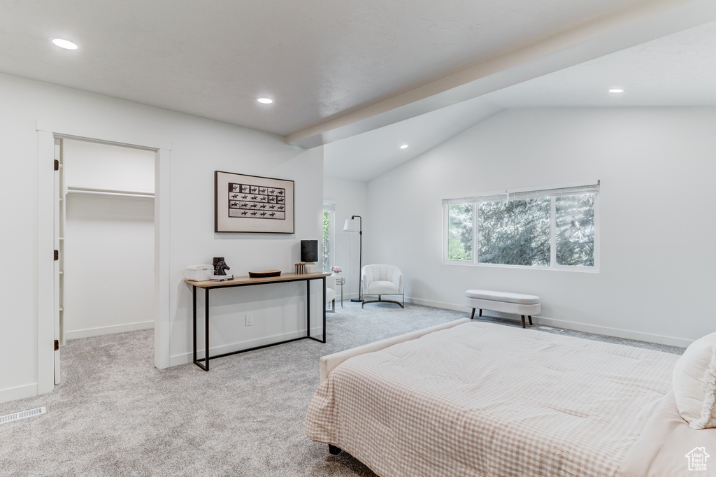 Carpeted bedroom featuring recessed lighting, vaulted ceiling, a walk in closet, and baseboards