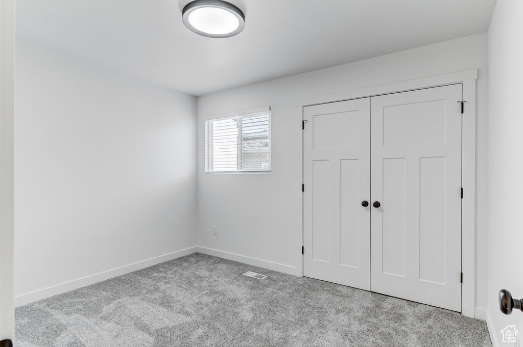 Unfurnished bedroom with carpet, baseboards, and a closet
