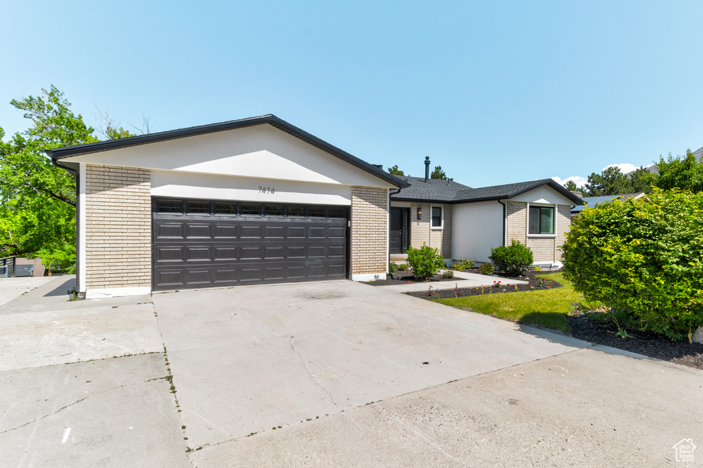 Ranch-style house with brick siding, a garage, and driveway