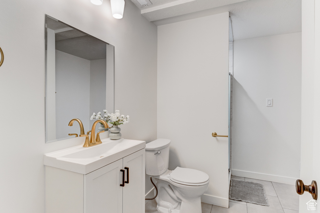 Bathroom featuring vanity, tile patterned floors, toilet, and baseboards
