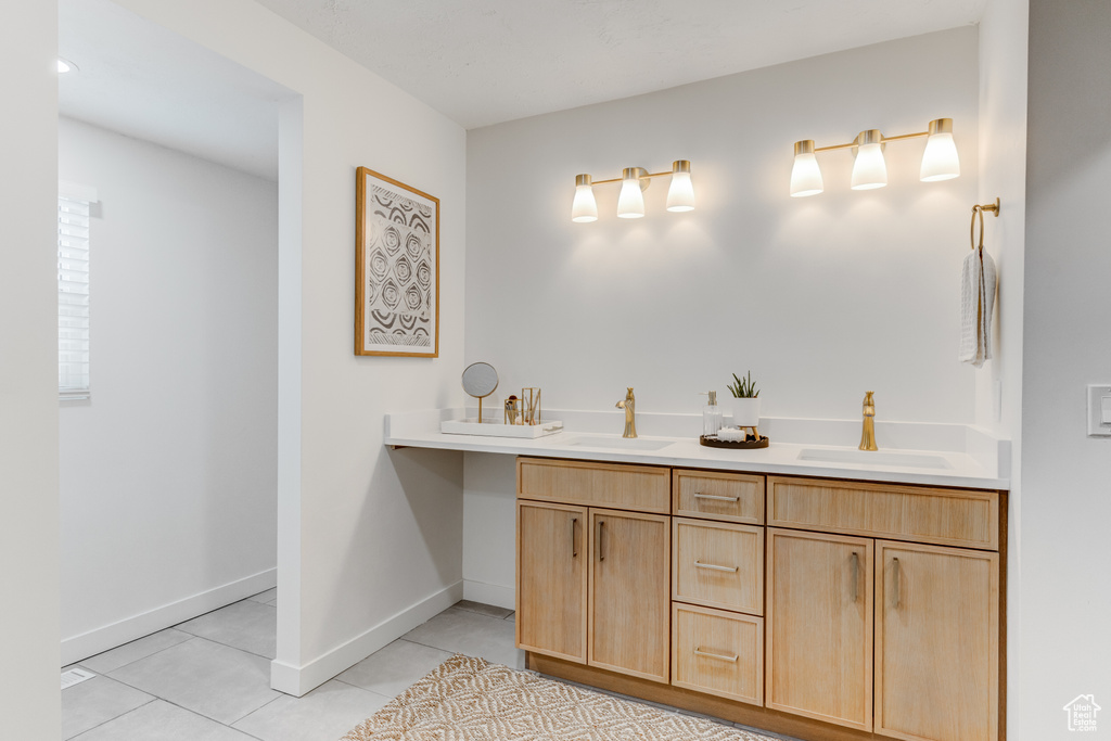 Full bath with tile patterned flooring, double vanity, and baseboards