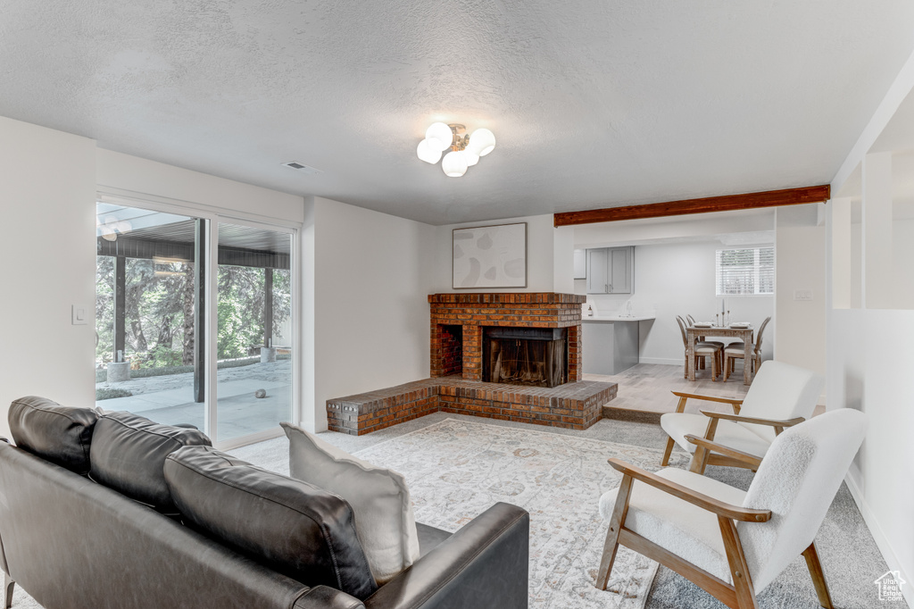Living room with a fireplace, a textured ceiling, and baseboards
