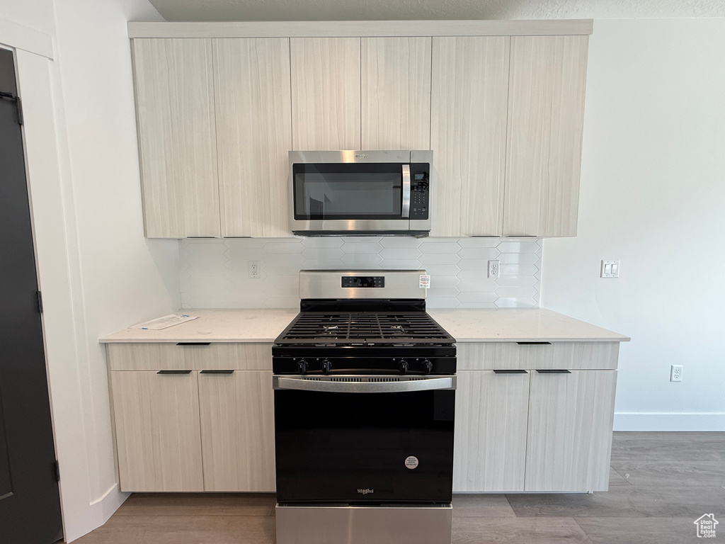 Kitchen featuring light brown cabinetry, appliances with stainless steel finishes, and modern cabinets