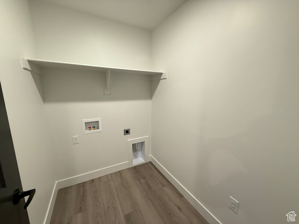 Clothes washing area with hookup for an electric dryer, laundry area, dark wood finished floors, baseboards, and hookup for a washing machine