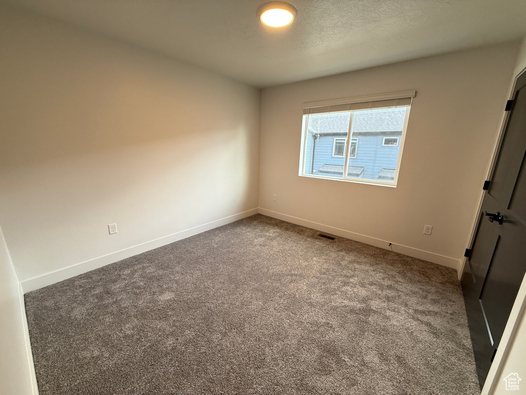Unfurnished bedroom with carpet flooring, baseboards, and visible vents