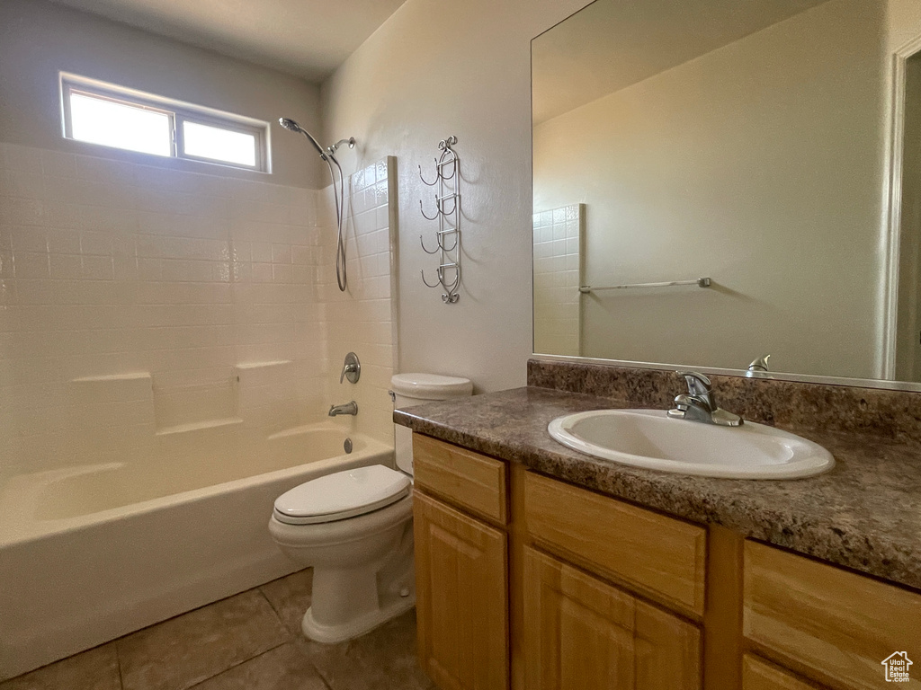 Bathroom featuring toilet, vanity, shower / tub combination, and tile patterned floors