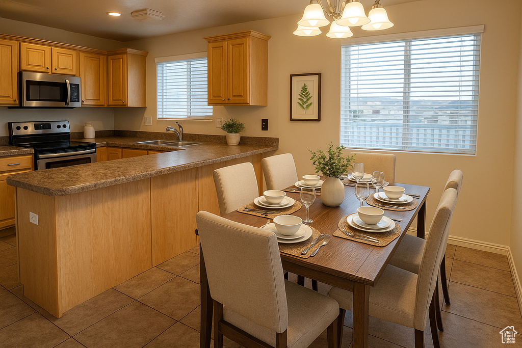 Kitchen featuring appliances with stainless steel finishes, a sink, dark countertops, light tile patterned flooring, and recessed lighting
