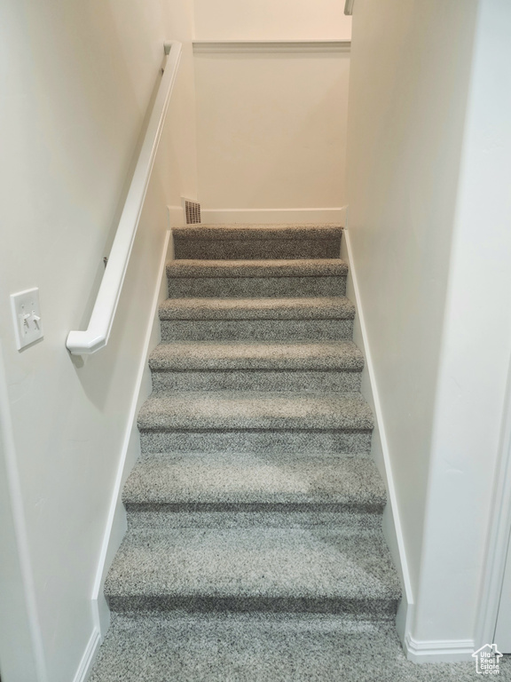 Stairway with carpet floors and baseboards