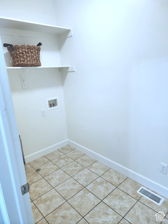 Laundry area featuring washer hookup, baseboards, and tile patterned flooring