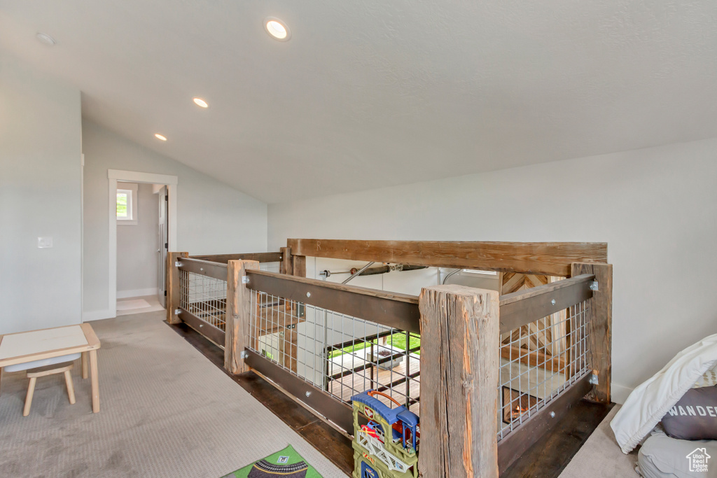 Hall with an upstairs landing, vaulted ceiling, baseboards, and recessed lighting