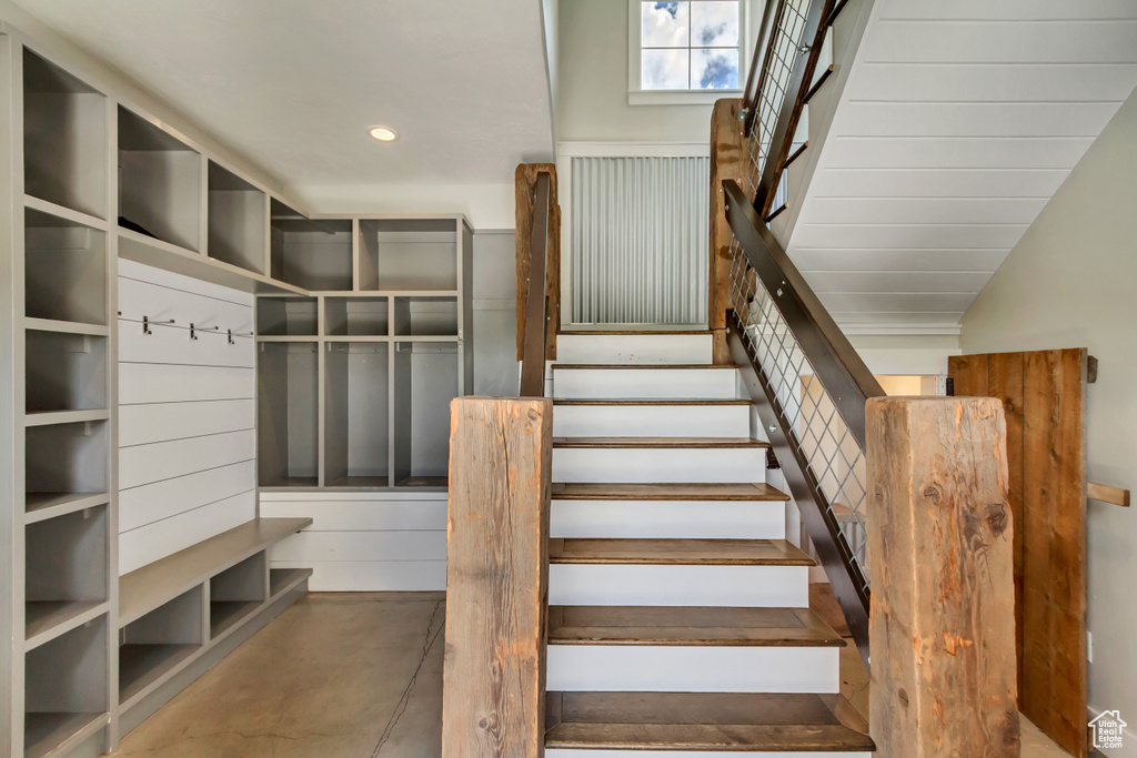 Staircase featuring concrete flooring and recessed lighting