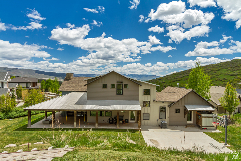 Rear view of house with a patio, a mountain view, and roof with shingles