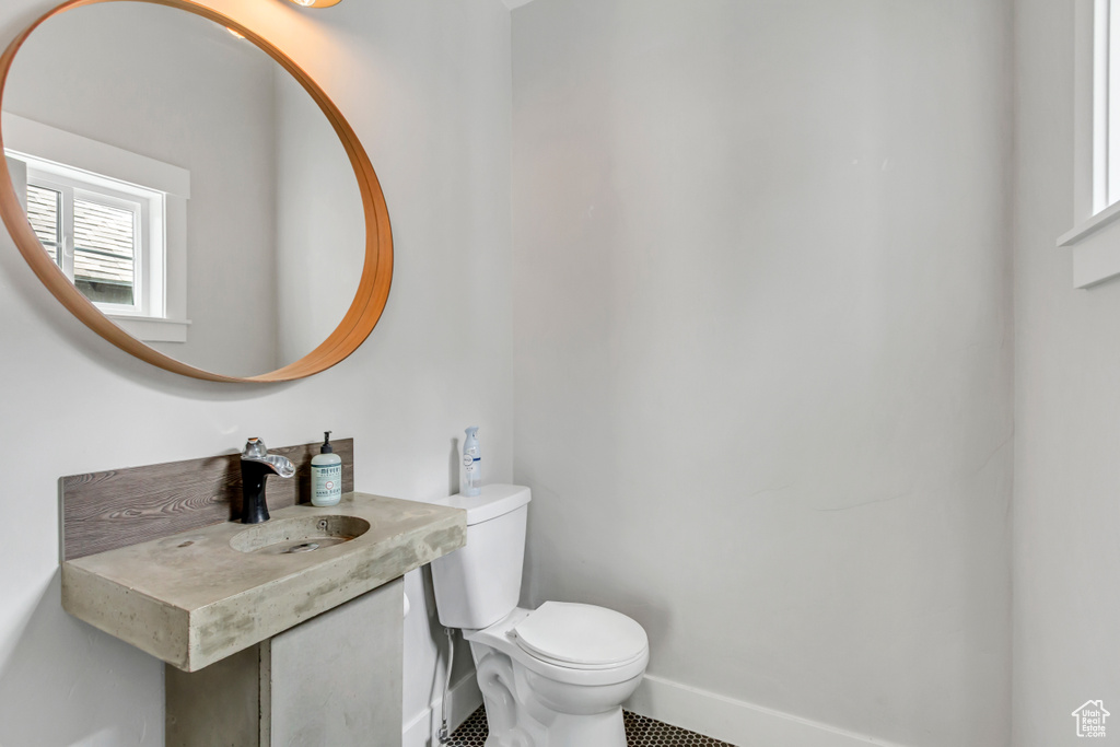 Bathroom with toilet, a sink, and baseboards
