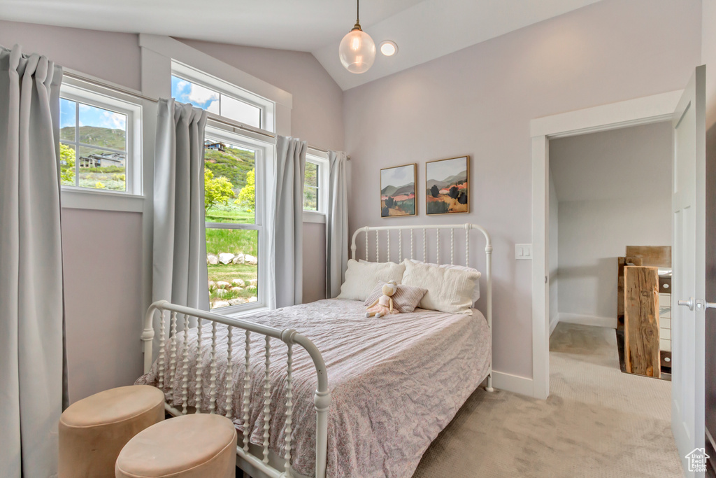 Carpeted bedroom featuring vaulted ceiling and baseboards