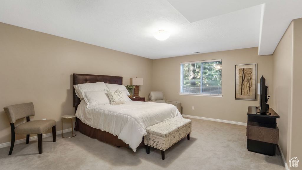 Bedroom featuring light colored carpet and baseboards