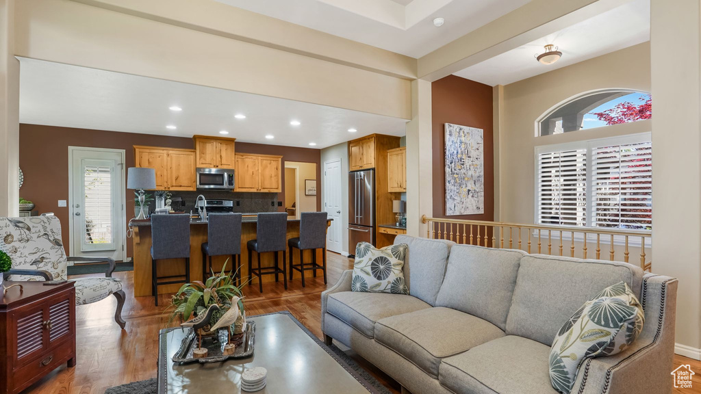 Living area with light wood-style floors and recessed lighting