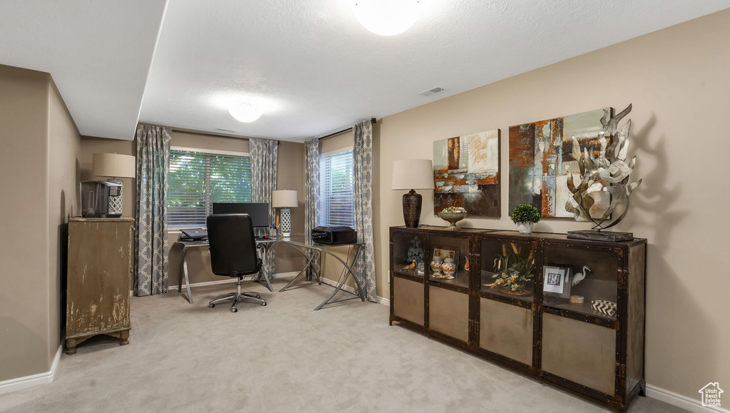 Carpeted home office featuring baseboards
