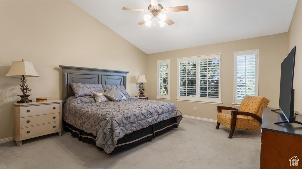 Bedroom with light carpet, vaulted ceiling, baseboards, and a ceiling fan