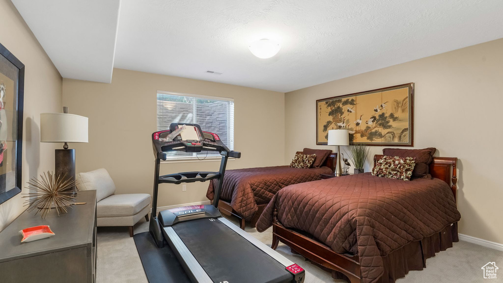 Bedroom featuring light carpet and baseboards