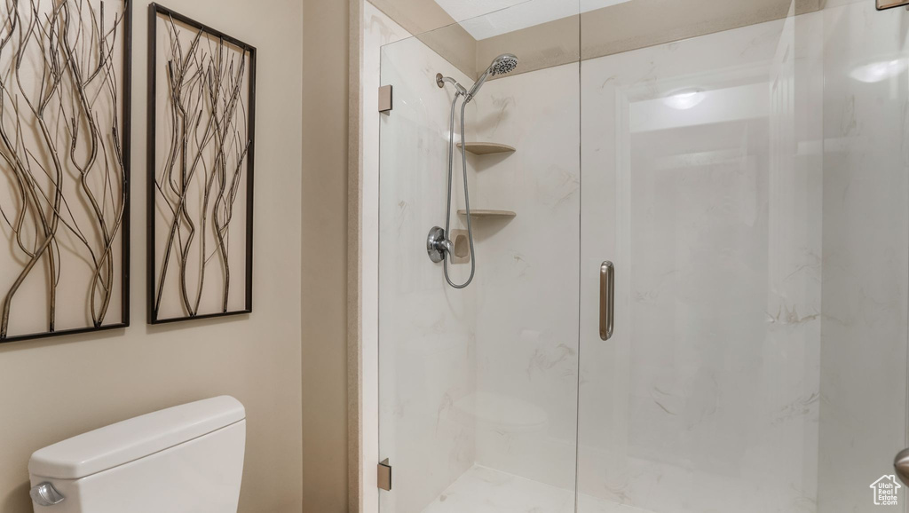 Full bathroom featuring toilet and a shower stall