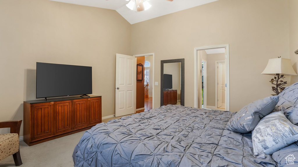 Bedroom featuring light colored carpet, high vaulted ceiling, and baseboards