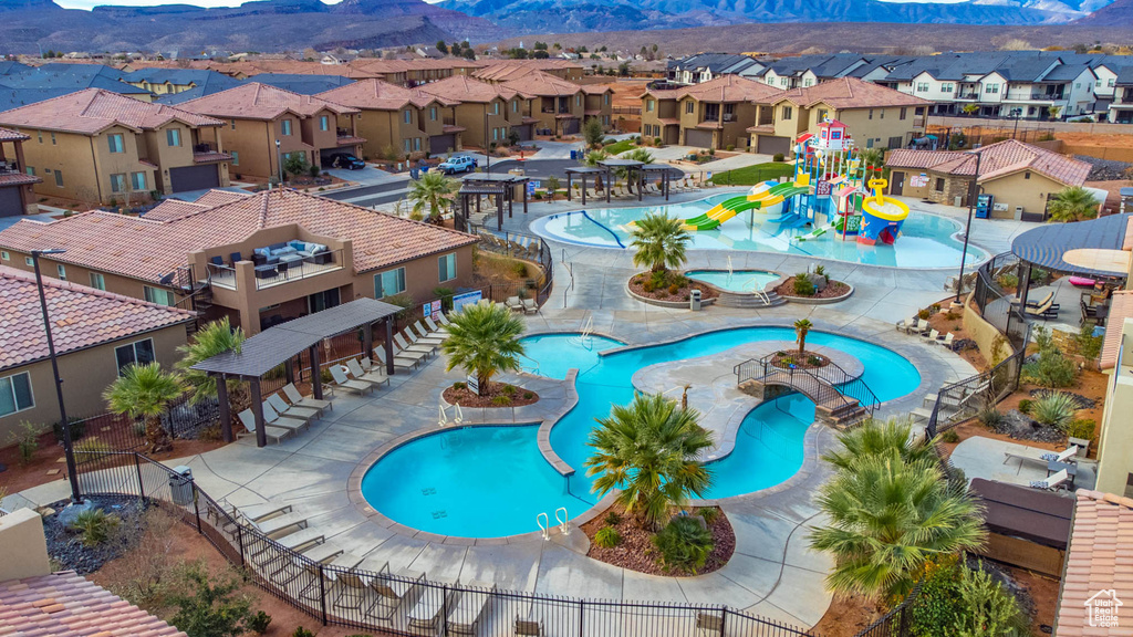 Community pool featuring a water play area, a residential view, and a mountain view