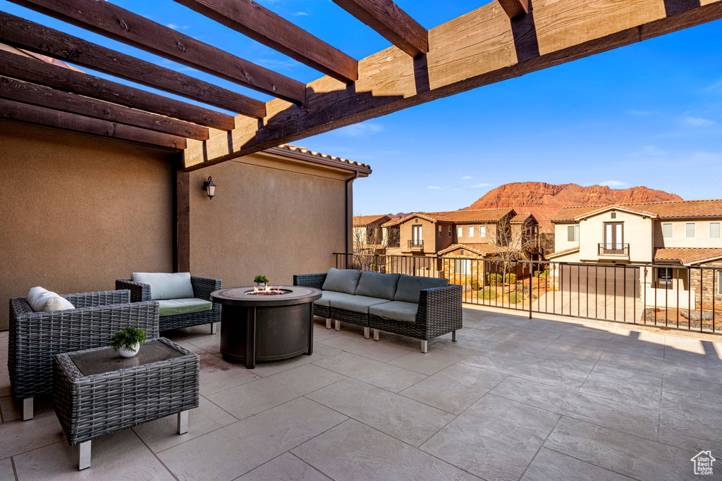 View of patio / terrace featuring a pergola, an outdoor living space with a fire pit, a residential view, and a mountain view